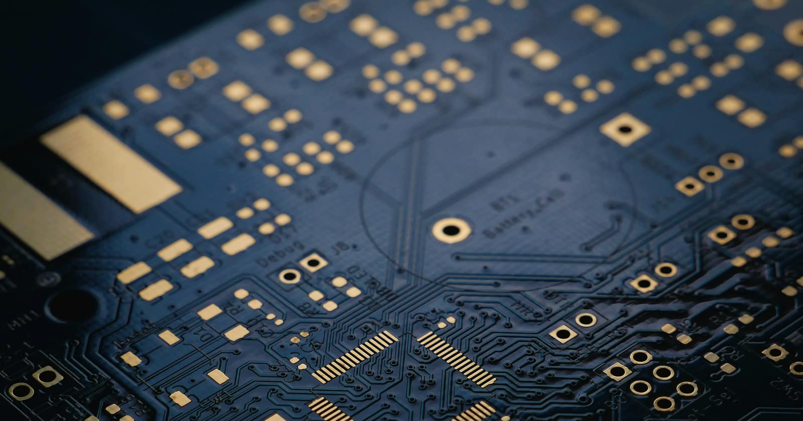 A close-up of a dark blue printed circuit board with gold contacts, photographed in Mysore