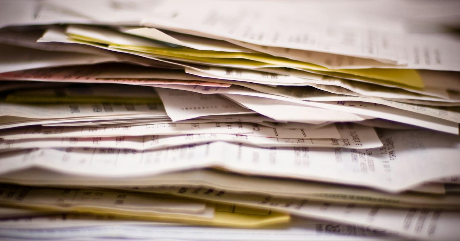 A thick stack of papers and invoices, seen close up