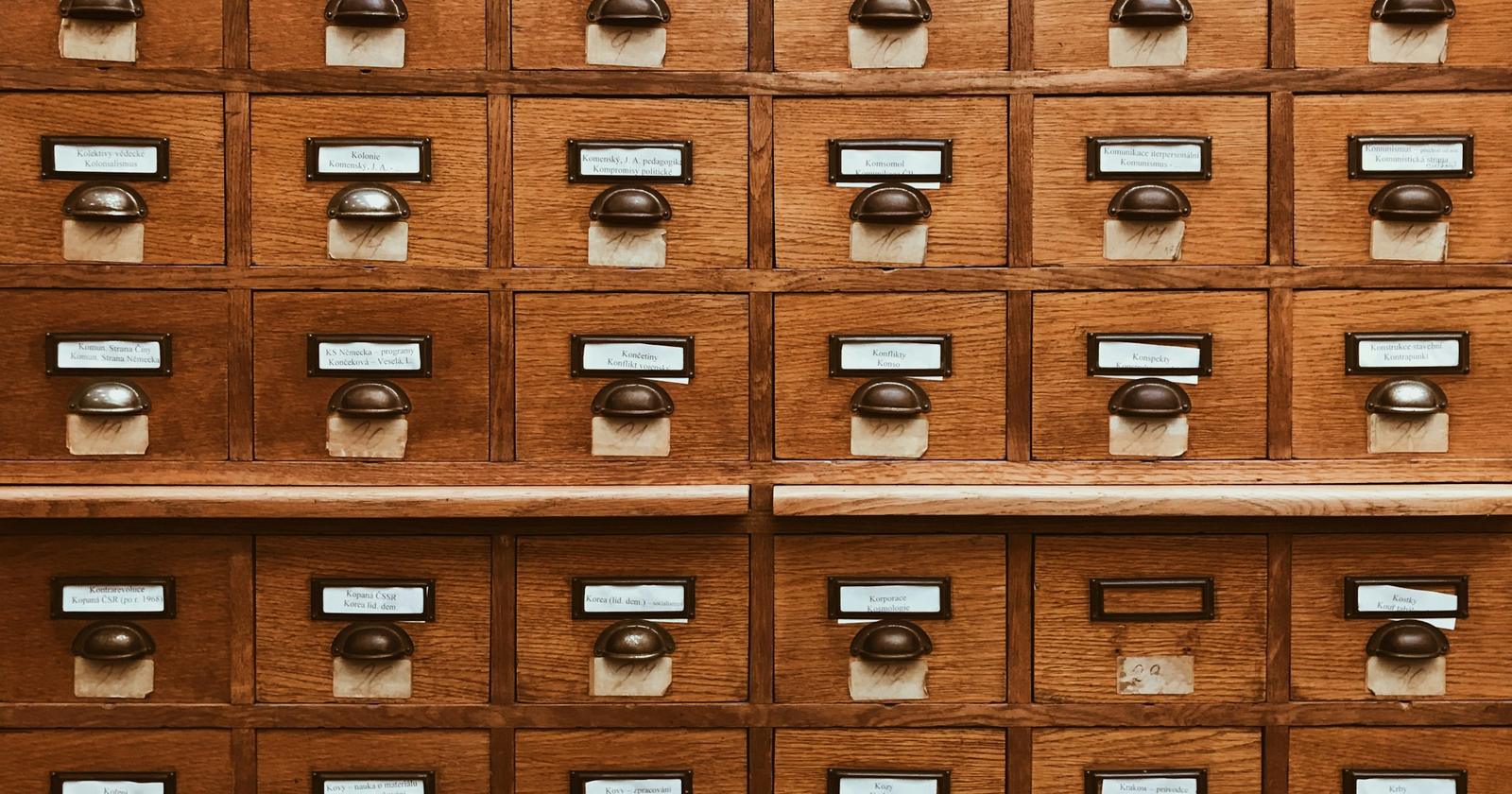 Rows of wooden card-catalogue drawers, each with a small label holder