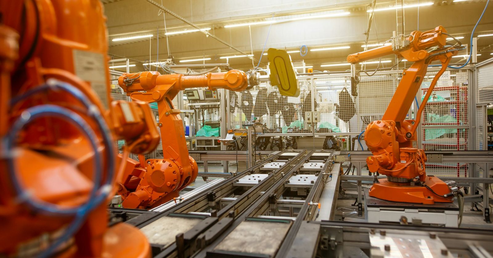 A factory floor of orange machines in a long row, the kind of plant an inverted duty structure describes