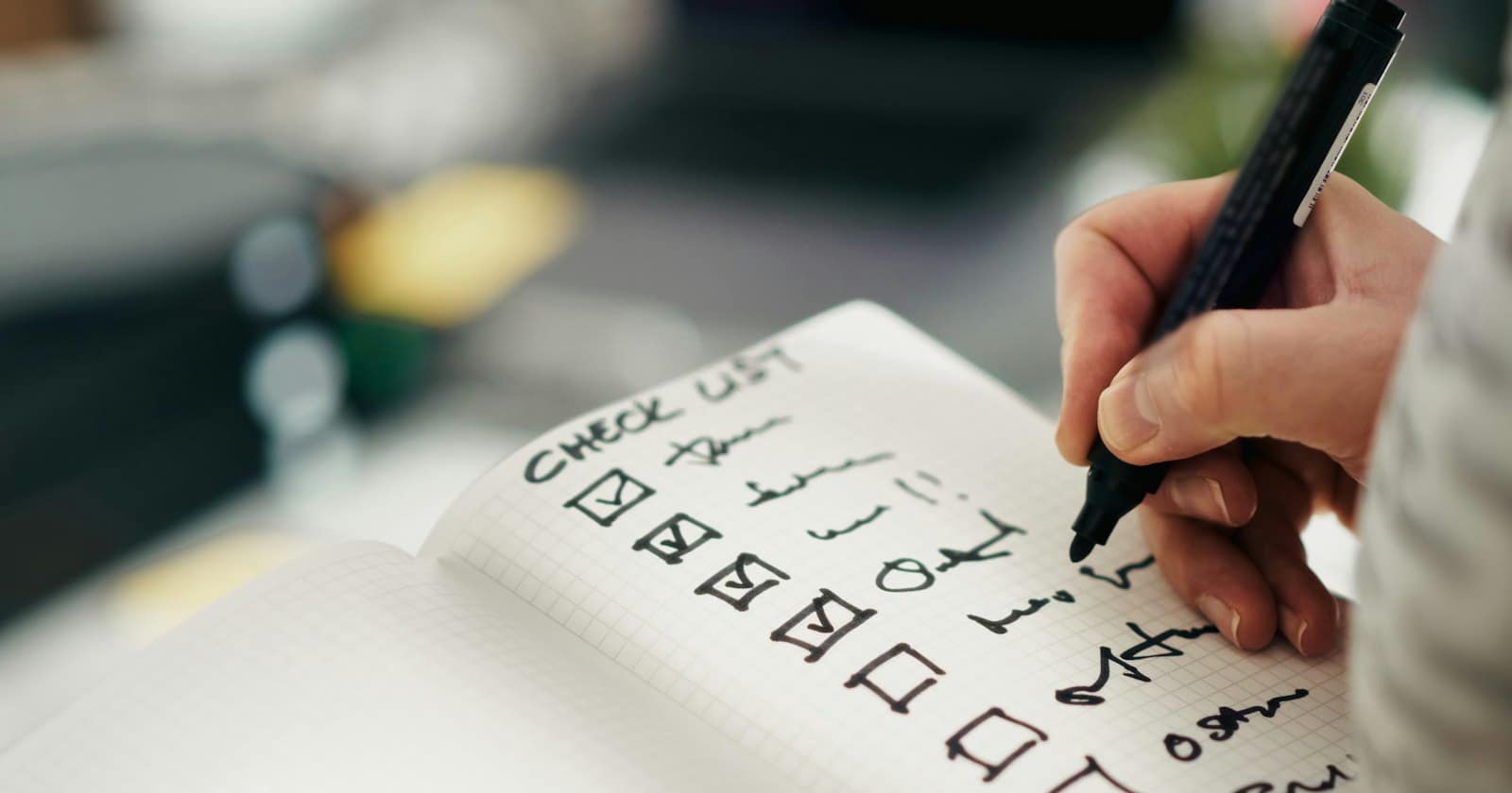 A hand writing a checklist and ticking the boxes one by one
