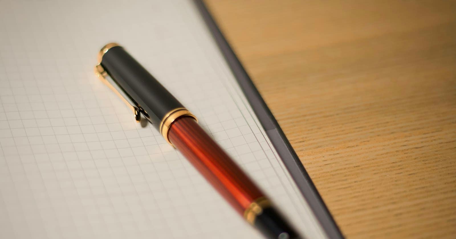 A fountain pen lying on squared paper