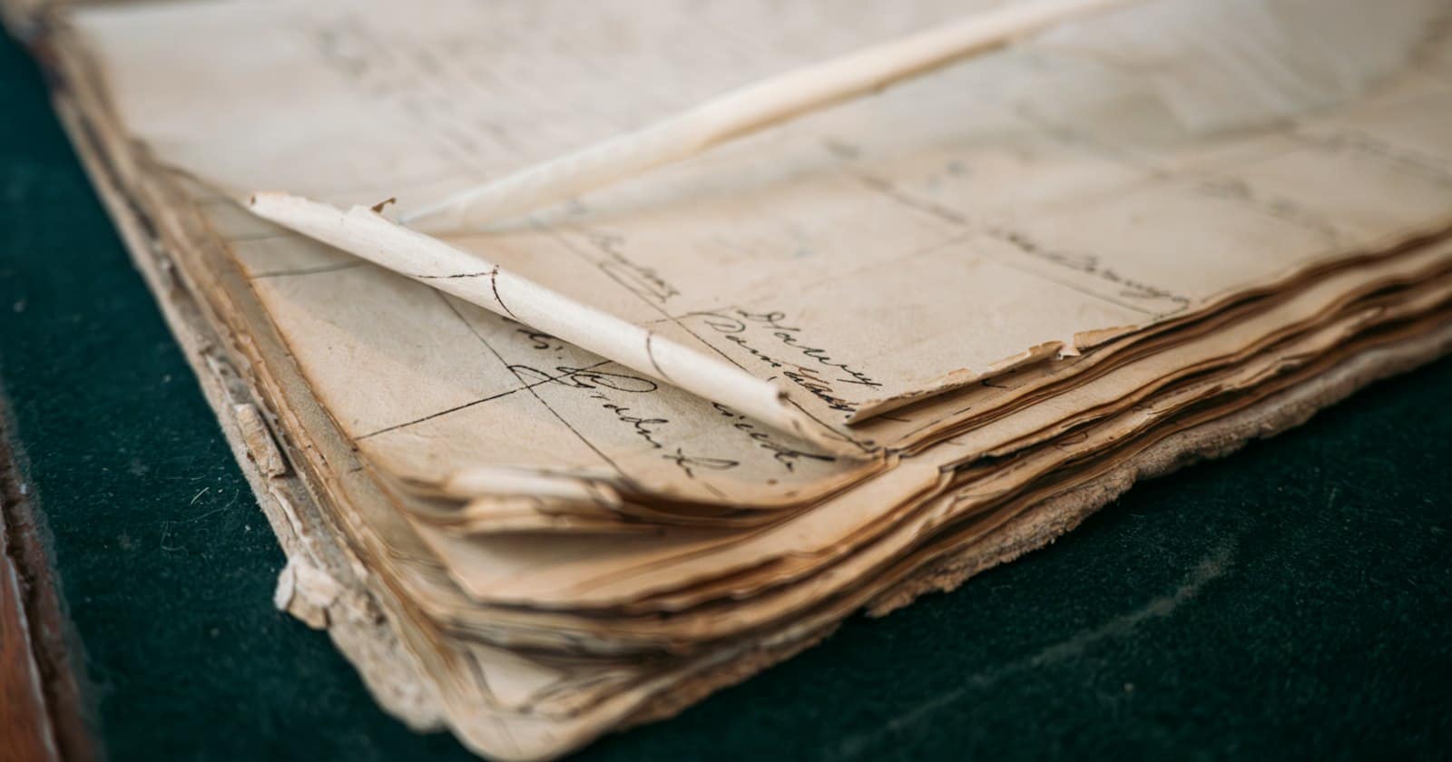 An old ledger lying open, its pages worn at the edges