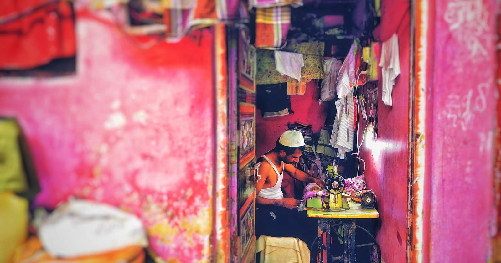 A man working at a sewing machine in a small workshop