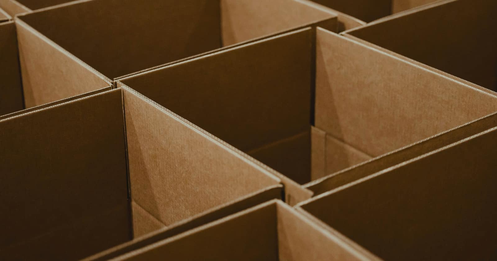 Rows of open brown cardboard boxes seen from above