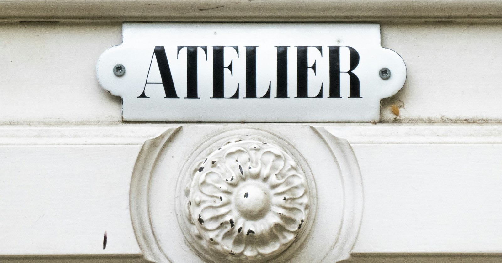 A close-up of a small nameplate sign fixed to an office door