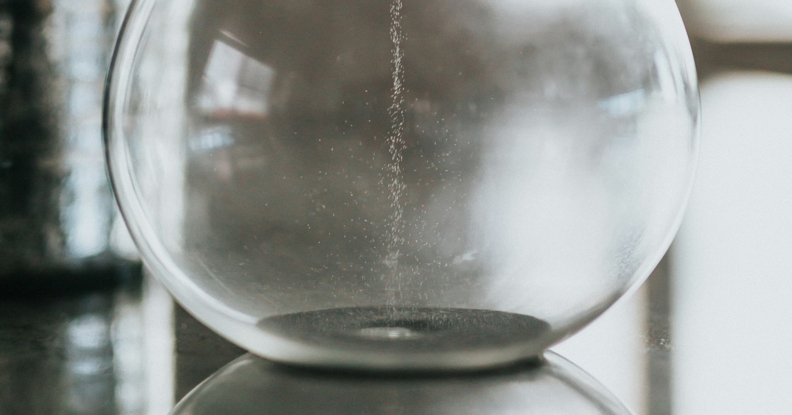 An hourglass of clear glass, its sand part run through